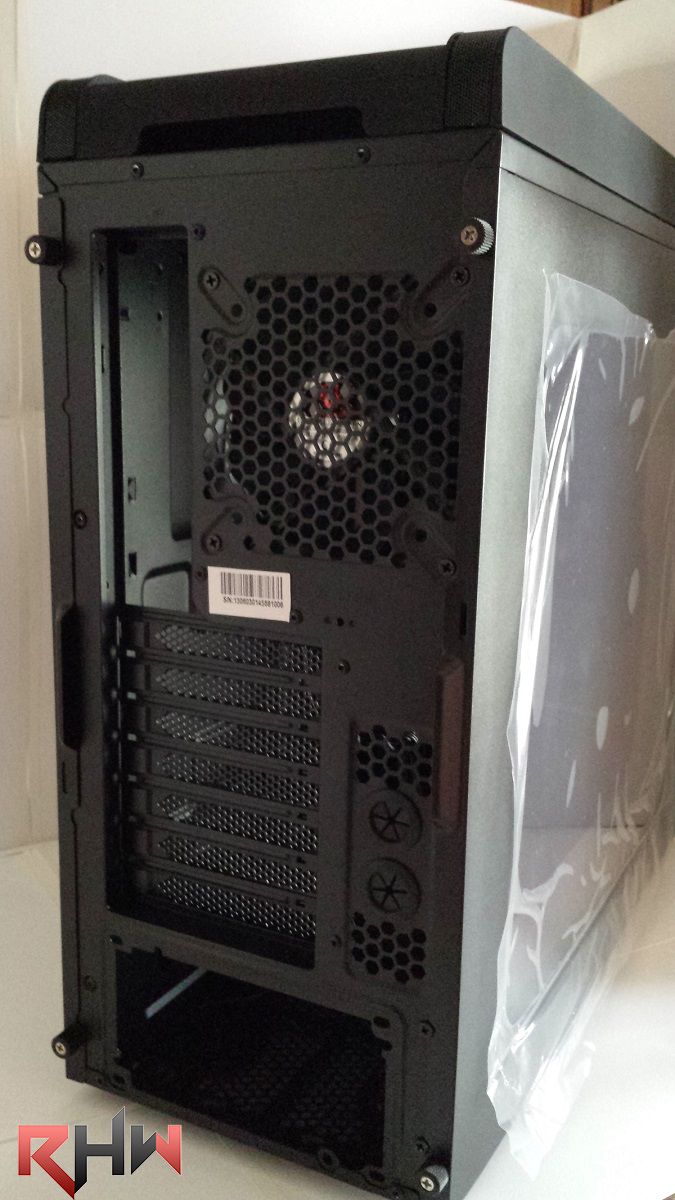 Nella parte posteriore il cabinet si presenta con una soluzione piuttosto classica e presente nella maggior parte dei midTower, nella parte di destra trova spazio l’alloggiamento traforato per la ventola da 120mm inclusa nel bundle, rispettivamente a sinistra troviamo lo spazio dedicato al pannello I/O delle schede madri. Spostandoci sulla parte inferiore troviamo i 7 slot per il montaggio delle periferiche PCI.E, di fianco a queste sono presenti due fori per il passaggio dei tubi presenti negli impianti di raffreddamenti a liquido. Questi fori si presentano molto utili qualora si scelga di adottare un radiatore avente dimensioni piuttosto grandi, tale da non poter essere installato all’ interno del Ronin. Termina il retro del case uno slot destinato al montaggio dell’alimentatore.